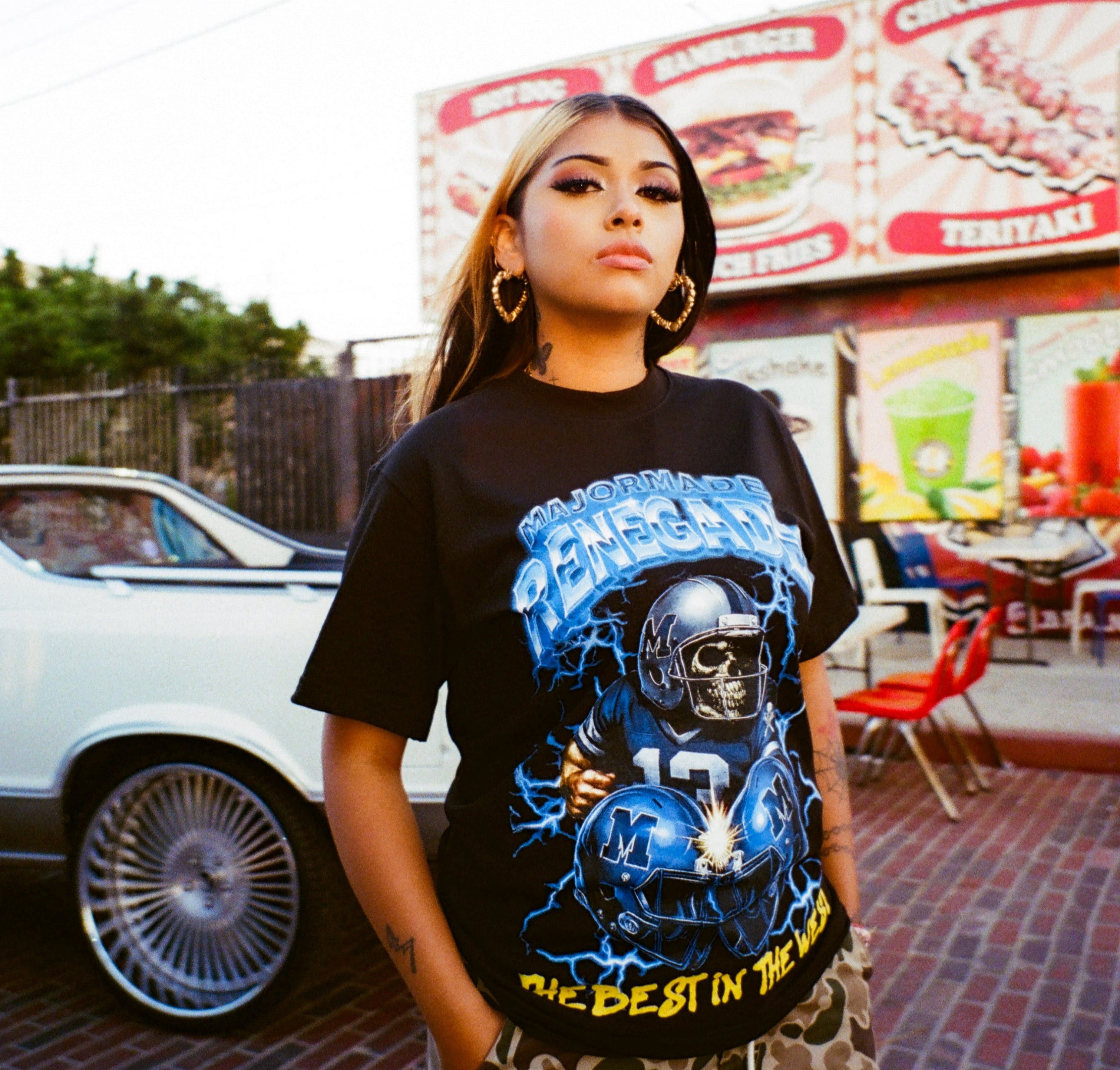 Person wearing a graphic t-shirt with a skull design in an urban setting